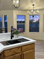 Kitchen featuring a chandelier, light wood-style floors, a textured ceiling, and a sink