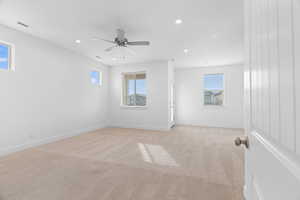 Empty room featuring light colored carpet, visible vents, baseboards, recessed lighting, and a ceiling fan