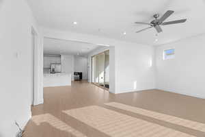 Unfurnished living room with recessed lighting, light wood finished floors, a ceiling fan, and baseboards