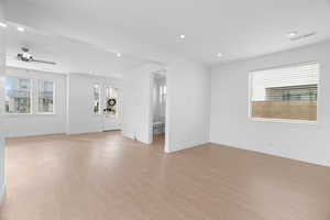Unfurnished living room featuring light wood-type flooring, visible vents, a healthy amount of sunlight, and a ceiling fan