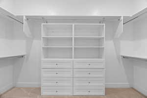 Walk in closet with light carpet