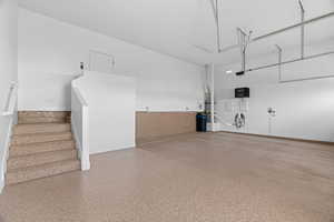 Garage featuring baseboards and a garage door opener