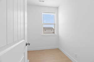 Spare room featuring baseboards, visible vents, and light wood finished floors