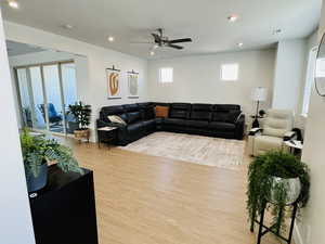 Living room with wood finished floors, recessed lighting, and a ceiling fan