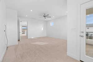 Unfurnished room with light colored carpet, visible vents, baseboards, recessed lighting, and a ceiling fan