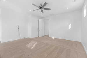 Empty room with light colored carpet, visible vents, recessed lighting, and a ceiling fan