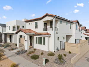 Mediterranean / spanish-style house featuring stucco siding, a gate, a tiled roof, and a balcony