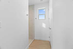 Hall featuring visible vents, light wood-style flooring, and baseboards