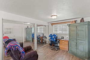 Home office with a textured ceiling and light wood finished floors