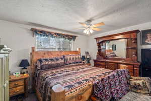 Bedroom with a textured ceiling, ceiling fan, and wood finished floors