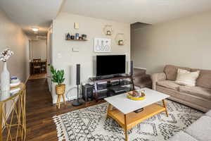 Living room featuring a textured ceiling, wood finished floors, and baseboards