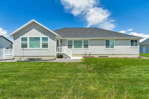 Back of house featuring a yard and stucco siding