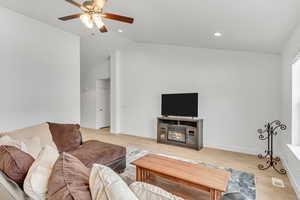 Living room featuring recessed lighting, light wood-style floors, vaulted ceiling, and ceiling fan