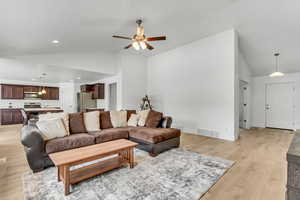 Living room featuring vaulted ceiling, recessed lighting, light wood-style flooring, a ceiling fan, and visible vents
