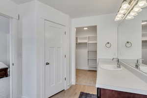 Ensuite bathroom with ensuite bathroom, vanity, and wood finished floors