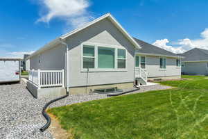 Back of property with stucco siding and a lawn