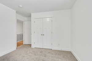 Unfurnished bedroom with a closet, baseboards, and carpet floors