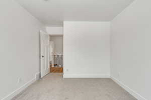 Carpeted empty room with baseboards