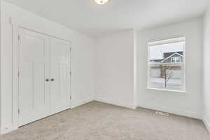 Unfurnished bedroom featuring a closet, visible vents, baseboards, and carpet floors