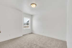 Unfurnished room featuring light colored carpet, baseboards, and visible vents