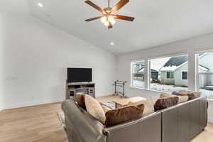 Living area featuring light wood-style flooring, a ceiling fan, lofted ceiling, and recessed lighting