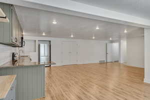 Kitchen featuring gray cabinets, light wood finished floors, a sink, and stainless steel appliances