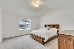 Bedroom featuring baseboards, carpet, and lofted ceiling