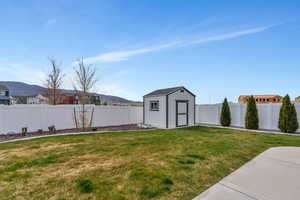 View of yard featuring an outdoor structure, a shed, and a fenced backyard