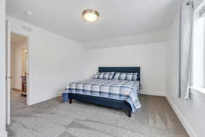 Bedroom featuring baseboards, visible vents, lofted ceiling, and carpet