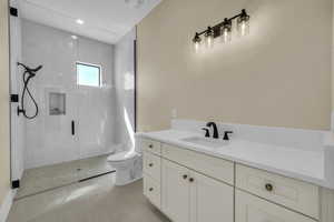 Full bathroom with toilet, a stall shower, tile patterned flooring, and vanity