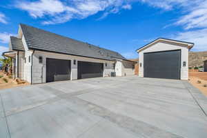 View of property exterior with cooling unit, concrete driveway, and stucco siding
