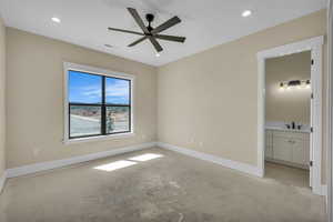 Unfurnished bedroom featuring connected bathroom, unfinished concrete floors, baseboards, visible vents, and a sink