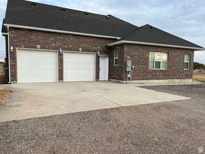 Exterior space featuring brick siding, a shingled roof, concrete driveway, and an attached garage