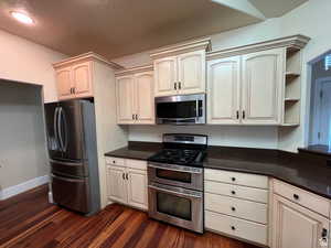 Kitchen featuring stainless steel appliances, recessed lighting, dark wood finished floors, and baseboards