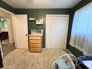 Carpeted bedroom featuring a closet