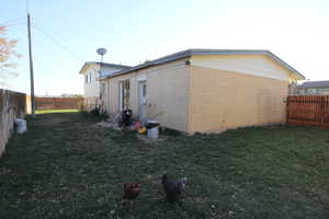 View of side of property featuring a yard, a fenced backyard, and brick siding