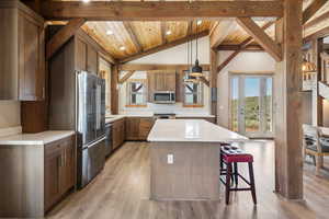 Kitchen featuring lofted ceiling with beams, a kitchen island, light countertops, wood ceiling, and appliances with stainless steel finishes