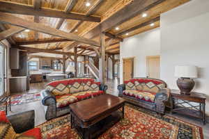 Living room with wooden ceiling, wood finished floors, vaulted ceiling with beams, stairs, and recessed lighting