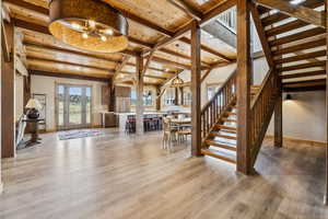 Stairs featuring baseboards, wood finished floors, vaulted ceiling with beams, and wood ceiling