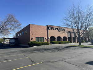 View of building exterior with uncovered parking
