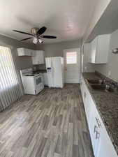 Kitchen with ceiling fan, a sink, white appliances, and a textured ceiling 2903 Jackson
