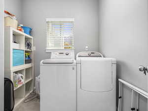Clothes washing area featuring tile patterned flooring, separate washer and dryer, and laundry area