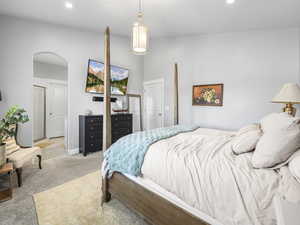 Bedroom with recessed lighting, arched walkways, and light carpet
