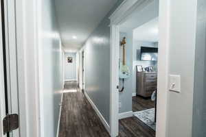 Hallway featuring recessed lighting, dark wood finished floors, and baseboards