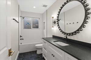 Bathroom featuring tile patterned floors, toilet, visible vents, shower / washtub combination, and vanity