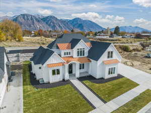Modern farmhouse with board and batten siding, covered porch, a mountain view, metal roof, and a standing seam roof
