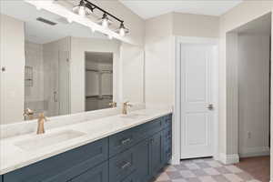 Full bath featuring tile patterned floors, visible vents, a sink, and a shower stall