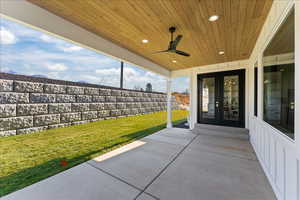 View of patio with a fenced backyard, a ceiling fan, french doors, and a mountain view