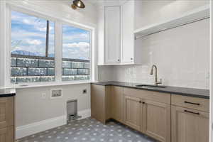 Laundry area featuring tile patterned floors, a sink, hookup for an electric dryer, baseboards, and washer hookup