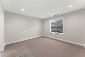 Carpeted spare room featuring recessed lighting and baseboards